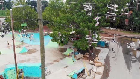 4K-Drone-Video-of-Shoes-Hanging-from-Power-Lines-near-Outdoor-Skatepark-at-the-River-Arts-District-in-Asheville,-NC