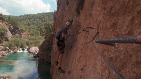 POV-Action-Cam-Junger-Kletterer-In-Klettersteig-Felswand-über-Wunderschönem-Fluss-Und-Wasserfall