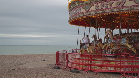 La-Gente-Disfruta-Montando-Un-Carrusel-De-Caballos-A-La-Antigua-Usanza-En-La-Playa-De-Brighton,-Reino-Unido