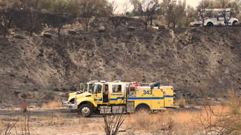 Emergency-vehicles-parked-while-fire-crews-take-a-break-in-the-arid-countryside