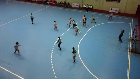 Toma-Estática-De-Equipos-De-Chicas-Entusiastas-Jugando-Un-Partido-De-Balonmano-En-La-Cancha-Azul-Reglamentaria,-Paraguay