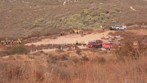 Los-Bomberos-Se-Están-Preparando-Con-Varios-Equipos-De-Ataque-Y-Camiones-De-Bomberos-En-Un-Mirador-Seco-Y-Cubierto-De-Maleza-Explorando-Su-Plan-De-Ataque