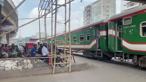 Locals-Waiting-For-Intercity-Train-To-Go-Past-In-Dhaka-Underpass,-Bangladesh-Before-They-Could-Cross-The-Road