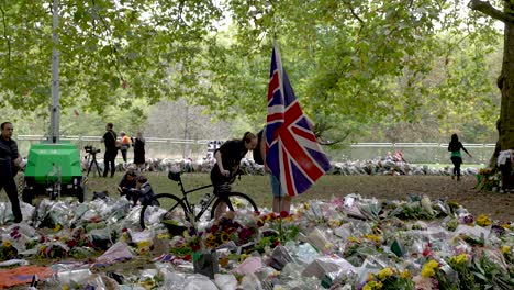 Große-Union-Jack-flagge,-Die-Im-Wind-Flattert,-Umgeben-Von-Floralen-Tributen-Für-Den-Tod-Von-Königin-Elizabeth-Ii-Im-Grünen-Park