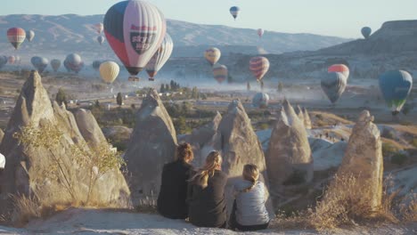 Novias-Sentadas-Viendo-Globos-Sobre-Capadocia-Al-Amanecer