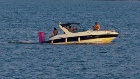 Grupo-De-Amigos-Divirtiéndose-En-Un-Viaje-En-Barco-Por-El-Lago,-Hora-Dorada-En-Cámara-Lenta