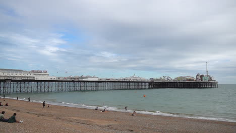 Los-Turistas-Disfrutan-De-La-Playa-De-Brighton-Cerca-Del-Muelle-Del-Palacio-De-Brighton-En-El-Día-Gris