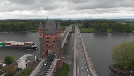 Aerial-shot-over-Nibelungenbrücke-in-Worms-with-a-ship-carrying-containers