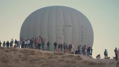 People-standing-on-Lovers-Hill-watching-a-hot-air-balloon-fly-past