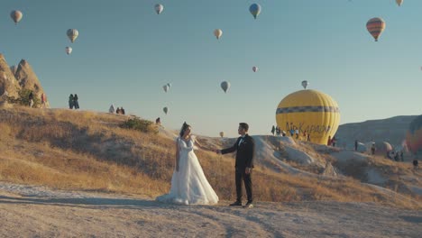 Novia-Y-Novio-Tomando-Fotos-Contra-El-Telón-De-Fondo-Del-Globo-De-Aire-Caliente-De-Capadocia