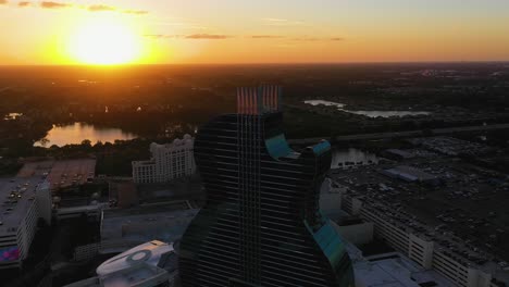 Vista-Aérea-Con-Vistas-Al-Hotel-Seminole-Hard-Rock-Iluminado-Por-El-Sol,-Puesta-De-Sol-En-Hollywood,-Florida,-Ee.uu.---Reversa,-Disparo-De-Drones