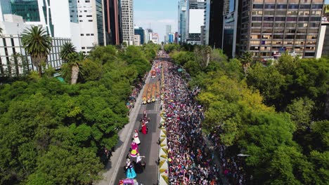 Vista-Aérea-Con-Vistas-Al-Desfile-Del-Día-De-Muertos,-En-La-Avenida-Reforma-En-La-Soleada-Ciudad-De-México