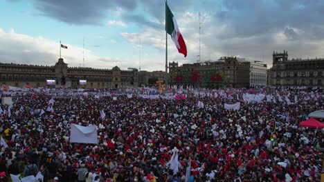 Vista-Aérea-De-La-Plaza-Del-Zócalo-Llena-De-Gente-Esperando-El-Discurso-Del-Presidente,-En-La-Ciudad-De-México---Reversa,-Tiro-Con-Drones