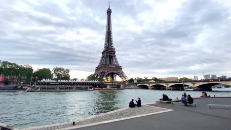 La-Gente-Pasa-El-Rato-A-Lo-Largo-Del-Río-Sena-Con-La-Torre-Eiffel-Y-El-Pont-D&#39;iéna-En-París,-Francia