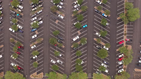 Vista-Aérea-De-Una-Gran-Cantidad-De-Autos-De-Diferentes-Colores-En-Un-Estacionamiento-Cerca-De-Un-Centro-Comercial