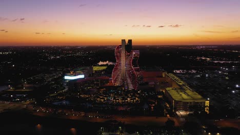 Vista-Aérea-Acercándose-Al-Hotel-Y-Casino-De-Hollywood-Seminole-Hard-Rock-Iluminado,-Noche-En-Florida,-Estados-Unidos