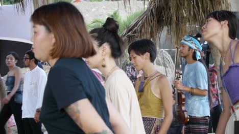 Grupo-De-Hombres-Y-Mujeres-Asiáticos-Balanceándose-Y-Bailando-Lentamente-Al-Ritmo-De-La-Música-En-Un-Festival-Al-Aire-Libre,-Filmado-Como-Tiro-Medio-Con-Movimiento-De-Mano