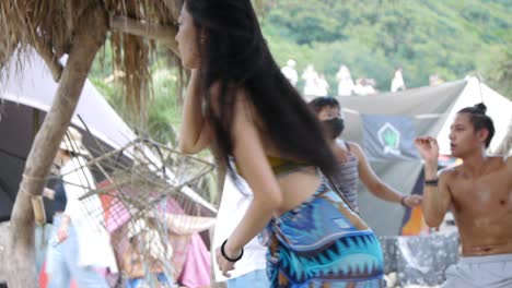 Asian-woman-dancing-and-swinging-ecstatically-with-hips,-filmed-as-medium-shot-with-slow-handheld-movement