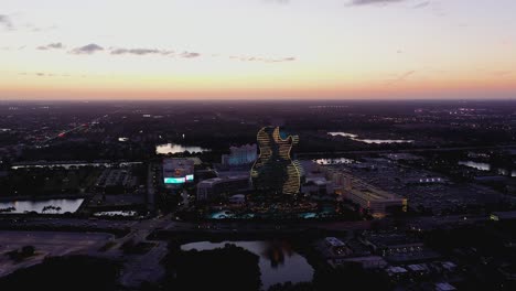 Vista-Aérea-Hacia-El-Hotel-Y-Casino-De-Rock-Duro-Seminole-Iluminado-Hollywood,-Anochecer-En-Florida,-Ee.uu.---Acercándose,-Disparo-De-Drones