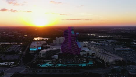 Hotel-De-Rock-Duro-Seminole-Con-Forma-De-Guitarra,-Iluminado-Durante-La-Puesta-De-Sol---Vista-Aérea