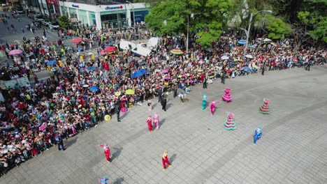 Vista-Aérea-De-Personas-Bailando-En-El-Desfile-Del-Día-De-Muertos,-En-La-Soleada-Ciudad-De-México