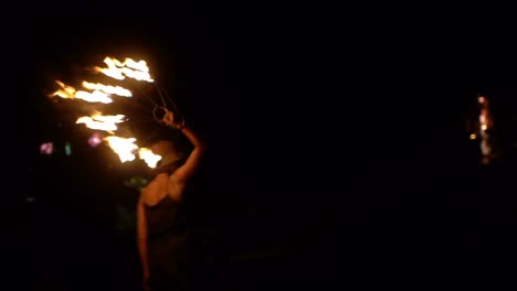 Mujer-Asiática-Girando-Y-Girando-Un-Solo-Ventilador-De-Fuego-En-La-Mano-Derecha-Durante-La-Noche,-Filmada-En-Estilo-Portátil