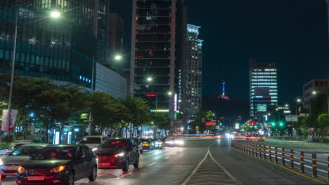 Seoul-Geschäftiger-Nächtlicher-Straßenverkehr-Im-Yongsan-gu-bezirk-In-Der-Nähe-Der-U-bahnstation-Yongsan-Und-Sinyoungsan,-Blick-Auf-Den-Namsan-turm-Und-Die-Skyline-Der-Stadt---Panoramisches-Schwenken