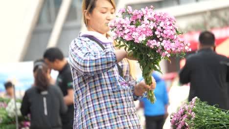 Kunming,-Yunnan,-China---September-1,-2022:-beautiful-seller-tidying-up-her-flowers-at-the-Kunming-Dounan-Flower-Market