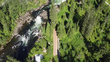 Person-riding-zipline-above-river-stream-in-Voss-climbing-and-Zipline-park-owned-by-Voss-Active---Sunny-day-erial-above-park-in-Voss-Norway