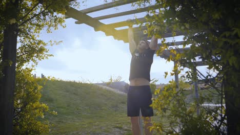 Toma-A-Cámara-Lenta-De-Un-Atleta-Musculoso-Haciendo-Pull-ups-En-Un-Arco