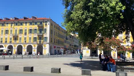 Gente-Caminando,-Sentada-Y-Descansando-En-El-Banco-Bajo-La-Sombra-De-Un-árbol-En-El-Parque-Garibaldi-En-Niza,-Francia