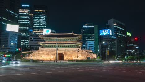 Lapso-De-Tiempo-Nocturno-De-La-Puerta-Namdaemun-Y-El-Tráfico-Contra-El-Horizonte-Urbano---Estático