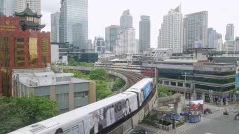 View-up-to-the-sky-of-highrise-building-in-financial-business-district-in-Silom-area-in-Bangkok-with-BTS-skytrain-passing-in-the-city-center-of-Bangkok