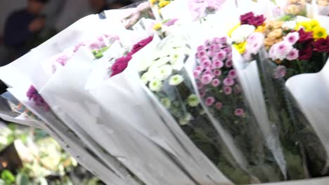 Kunming,-Yunnan,-China---September-1,-2022:-a-woman-carries-dozens-of-bouquets-of-flowers-in-a-cart-at-the-Kunming-Dounan-Flower-Market