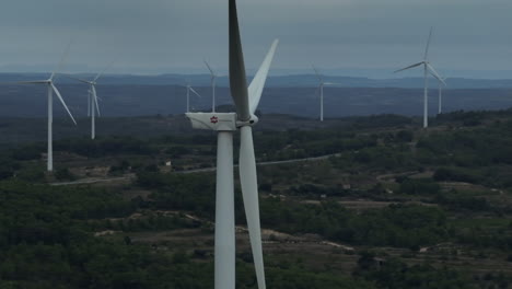 Majestic-aerial-of-still-wind-turbine-at-dusk,-flashing-light-active,-circling