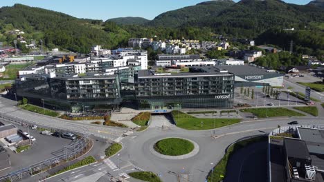 Antena-Distante-Acercándose-Al-Centro-Comercial-Horisont-Y-Edificio-De-Apartamentos-En-Asane-Outisde-Bergen-Noruega---Día-Soleado-De-Verano-Antena-Moviéndose-Hacia-El-Edificio-Sobre-La-Carretera