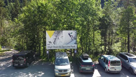 Hochseil--Und-Zipline-Park-Von-Voss-Active-In-Voss,-Norwegen---Luftbewegung-In-Richtung-Plakatschild-Am-Parkplatz