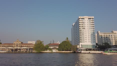 Zeitlupenansicht-Des-Flusses-Chao-Phraya-In-Bangkok-Mit-Bangkok-Higrise-Gebäude-Am-Ufer-Des-Flusses