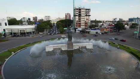 Vista-Aérea-Sobre-La-Estatua-Y-La-Fuente-En-La-Rotonda-De-Minerva,-Guadalajara,-México---Levantamiento,-Disparo-De-Drones