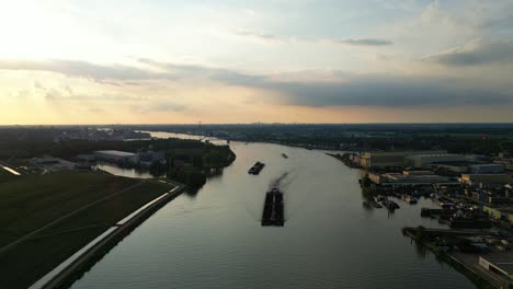 Aerial-Dolly-Over-Beneden-Merwede-During-Sunset-With-Silhouette-Of-Barge-Travelling-Along