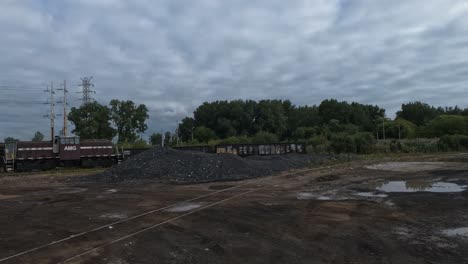 Train-driving-on-the-tracks-behind-the-mountain-of-rocks