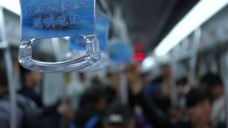 close-up-hand-holders-passengers-inside-the-train,-Kunming,-Yunnan,-China-on-September-2,-2022