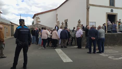 Religiosos-Católicos-Entraron-En-Procesión-A-La-Iglesia-Celebrando-El-Día-Del-Santo-Bajo-El-Control-De-La-Policía,-Día-Nublado,-Tiro-Bloqueado,-Poulo,-A-Coruña,-Galicia,-España