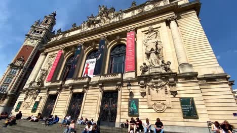 Gente-Sentada-Y-Pasando-El-Rato-En-Las-Escaleras-A-La-Entrada-De-La-ópera-De-Lille-Durante-El-Mediodía-En-Francia