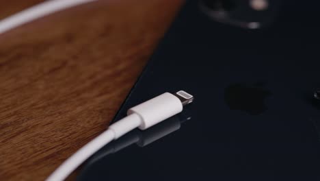 Primer-Plano-De-Los-Cables-De-Carga-Usb-c-Y-Lightning-De-Apple-En-Lados-Opuestos-De-Un-Iphone-De-Apple