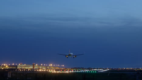 Luces-De-Pista-Que-Se-Reflejan-Bajo-El-Fuselaje-Del-Avión-Al-Aterrizar-En-El-Aeropuerto-De-Barcelona-A-La-Hora-Azul