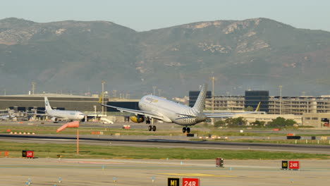 Vueling-Flugzeug-Landet-Bei-Sonnenaufgang-Am-Flughafen-Barcelona-Bei-Sonnenaufgang,-Tele