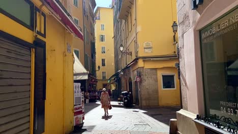 Pocas-Personas-Caminando-Por-La-Calle-Histórica-En-El-Casco-Antiguo-De-Niza,-Francia