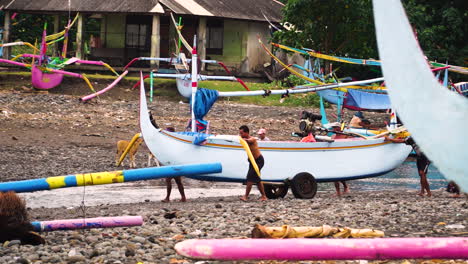 Fischer-Im-Ländlichen-Südostasiatischen-Dorf,-Das-Fischerboot-Am-Strandufer-Schiebt