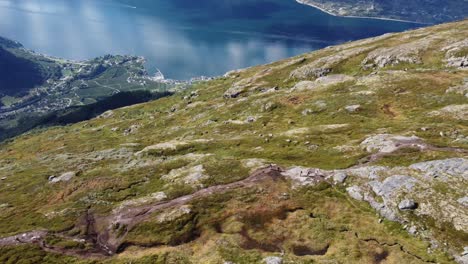 Muchas-Personas-Caminando-Por-La-Ruta-De-Senderismo-De-Queens-Con-Hermosas-Vistas-Panorámicas-Del-Fiordo-Y-El-Pueblo-De-Lofthus-Muy-Abajo---Antena-De-Verano-Hardanger-Noruega